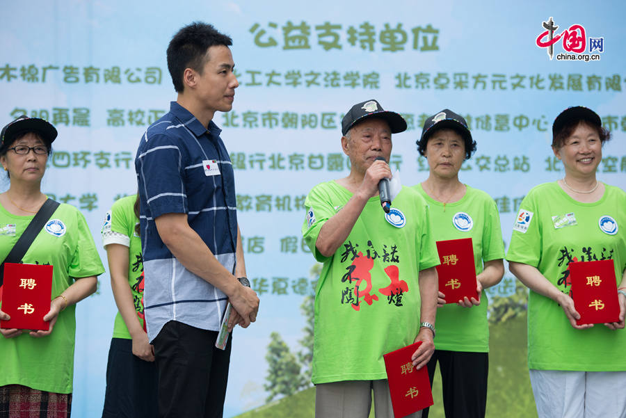 An elder traffic warden, Mr. Tian, 87, speaks about his idea why obeying traffic rules and eliminating jaywalking is important on Tuesday, July 8, 2014 at a public place in east Beijing&apos;s Chaoyang District. The local Chaoyang district government initiated a campaign to ensure better road safety by eliminating pedestrian running red light, among other jaywalking activities. [Photo by Chen Boyuan / China.org.cn]