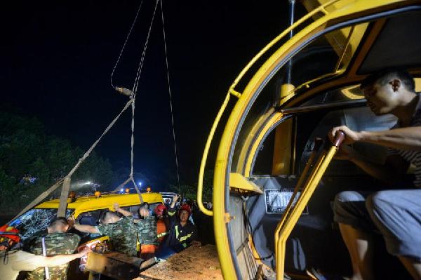Rescuers try to get a minivan out of water by using a crane in Changsha, Hunan province, July 11, 2014. [Photo/Xinhua]