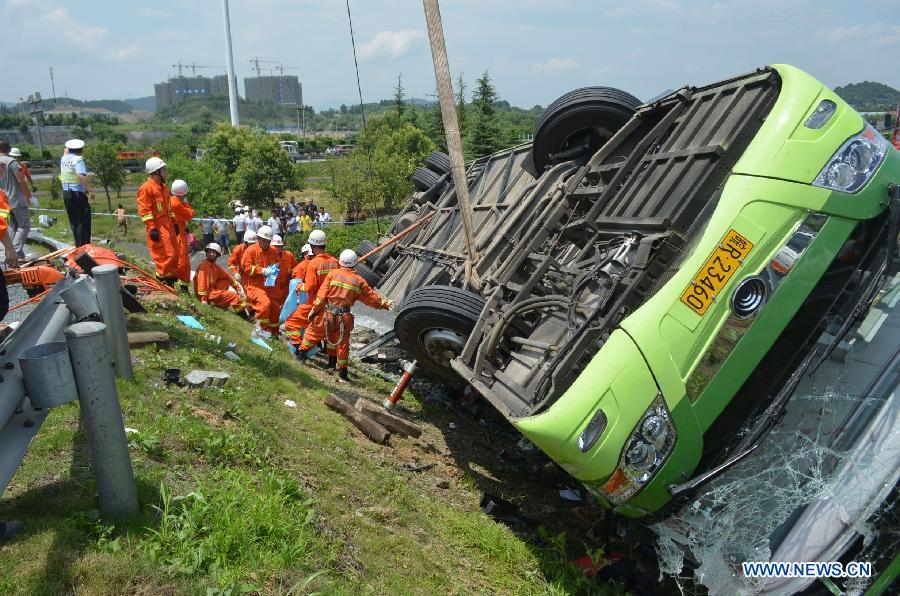 Rescuers work on the scene of a passenger coach rollover accident along the Hangzhou-Huizhou highway in Hangzhou, capital of east China's Zhejiang Province, July 12, 2014.[Photo/Xinhua]