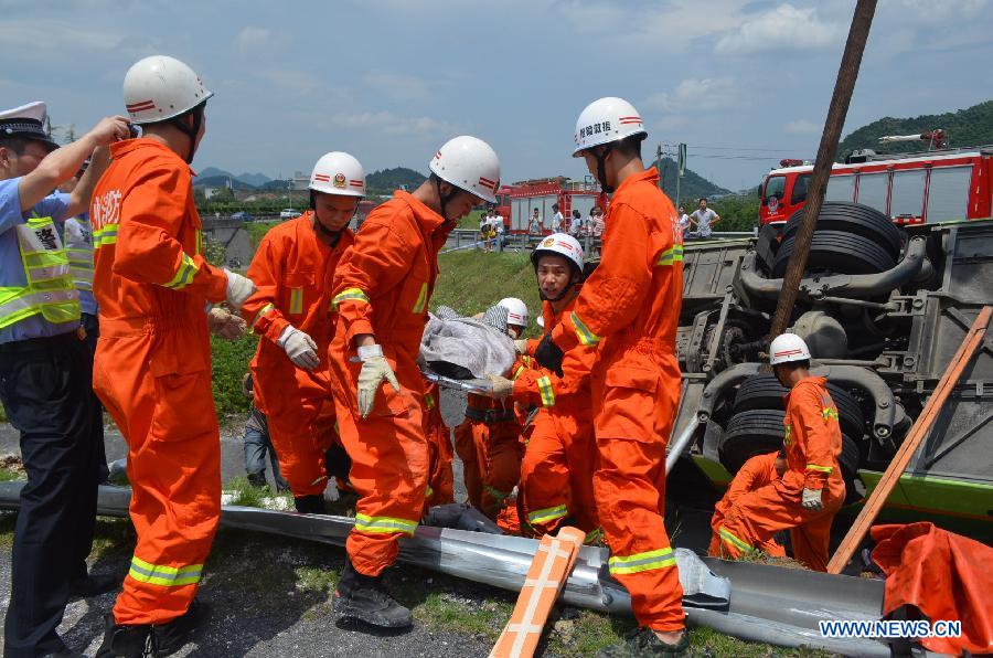 Rescuers work on the scene of a passenger coach rollover accident along the Hangzhou-Huizhou highway in Hangzhou, capital of east China's Zhejiang Province, July 12, 2014.[Photo/Xinhua]