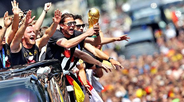 German national team players cheer as they ride in an open-deck bus to Berlin's landmark Brandenburg Gate to celebrate their FIFA World Cup title. Germany won its fourth World Cup crown after a 1-0 win over Argentina in the final at the Maracana Stadium in Rio de Janeiro. 