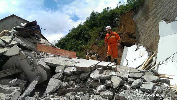 A rescuer works at the site of landslide in Dakuo Village of Zhijin County in the city of Bijie, southwest China's Guizhou Province, July 17, 2014. Six people died and another two were injured in the rain-triggered landslide here, local authorities said on Friday. Rainstorms have lashed Guizhou this week, triggering landslides and floods in many parts of the province.[Photo/Xinhua]