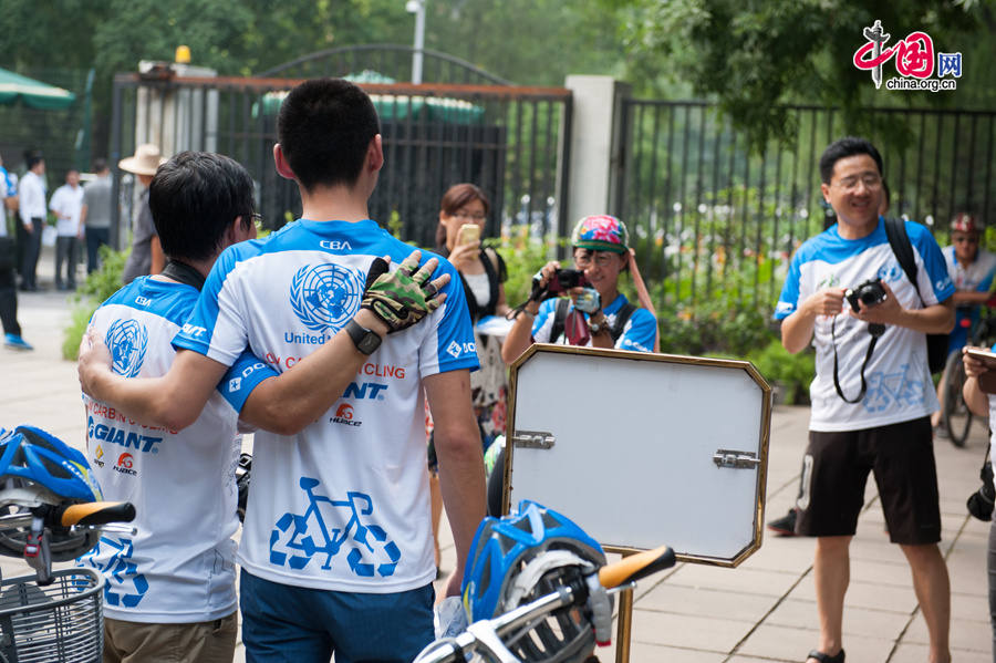 Participants of the UN &apos;Cycling for A Greener World&apos; event pose for pictures, dressed in special cycling jersies on Friday, July 18, in Beijing at the UN China HQ. [Photo by Chen Boyuan / China.org.cn]