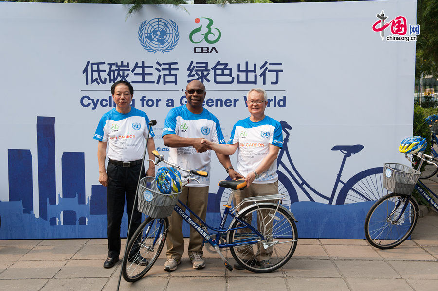 Alain Noudehou (M) poses for photos with Zheng Baotang, the President of Giant Bike (China) and Ma Zhongchao, Chairman of the China Bicycle Association (CBA) on the afternoon of Friday, July 18, 2014 at the UN China compound in Beijing, as Giant Bike officially donates 30 bikes to the UN. [Photo by Chen Boyuan / China.org.cn]