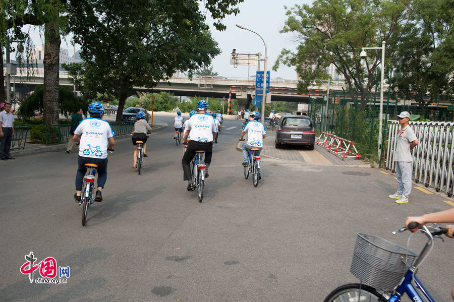 Cyclists peddle their way in Beijing&apos;s Sanlitun diplomatic area with tailor-made bike donated to the United Nations China system by Giant Bike, in a wish to promote greener traffic and a healthy lifestyle. [Photo by Chen Boyuan / China.org.cn]