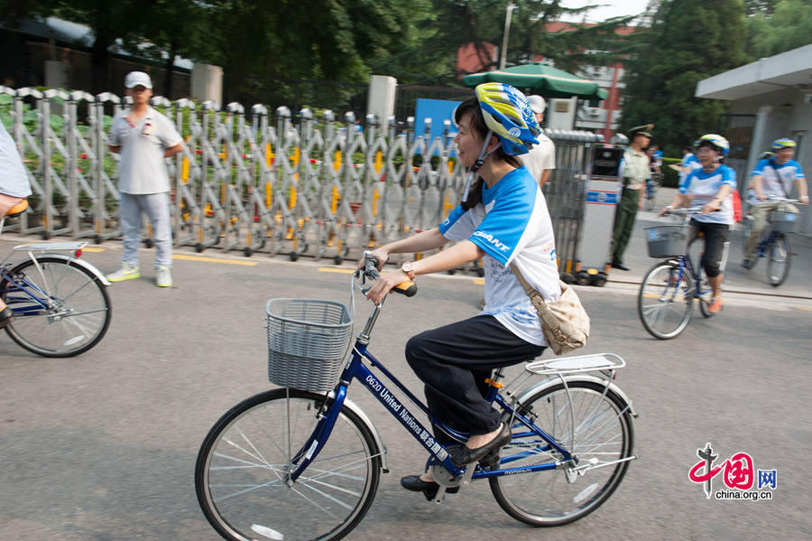 Cyclists peddle their way in Beijing&apos;s Sanlitun diplomatic area with tailor-made bike donated to the United Nations China system by Giant Bike, in a wish to promote greener traffic and a healthy lifestyle. [Photo by Chen Boyuan / China.org.cn]