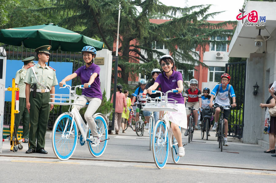 Two staff members with World Health Organisation (WHO) also participate in the &apos;Cycling for a Greener World&apos; event, but bring WHO&apos;s own bikes chracteristic of the UN blue color. [Photo by Chen Boyuan / China.org.cn]