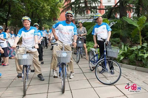 UN Resident Coordinator Alain Noudehou (C), President of Giant China Zheng Baotang (L) and Chairman of China Bicycle Association Ma Zhongchao mount the new UN bikes, ready for a test cycling on July 18, 2014. [Photo by Chen Boyuan / China.org.cn]