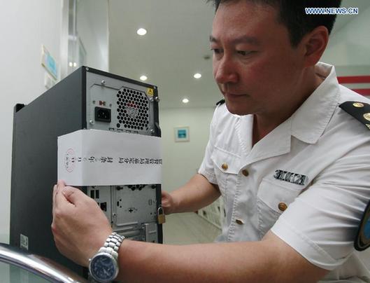 A working staff seals off a computer at Shanghai Husi Food Co., Ltd, a meat supplier for McDonald and KFC, in Shanghai, east China, July 20, 2014. Shanghai food and drug administration has suspended the operation of the food company suspected of supplying stale meat to McDonald and KFC outlets. [Xinhua] 