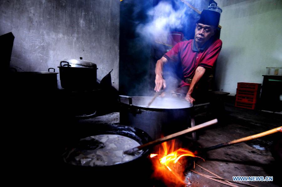 A man prepares porridge for Iftar at Sabiilurrosyaad Mosque in Yogyakarta, Indonesia, July 20, 2014. Muslims here eat porridge for Iftar during Ramadan month as tradition. [Photo/Xinhua]