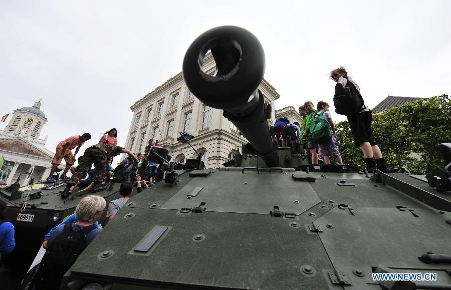 People climb up tanks on display during the National Day millitary parade in Brussels, Belgium, on July 21, 2014. [Photo/Xinhua]