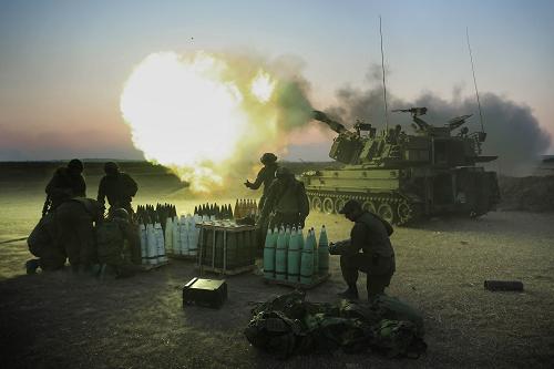 Israeli soldiers of the 155mm artillery cannons unit fire towards the Gaza Strip from their position near Israel's border with the coastal Palestinian enclave, on July 21, 2014. [Xinhua photo]