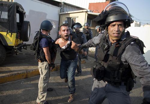 Israeli riot police arrest an Arab Israeli man during clashes that followed a protest against Israel's military offensive on the Gaza Strip, in the northern city of Nazareth, on July 21, 2014. [Xinhua photo]