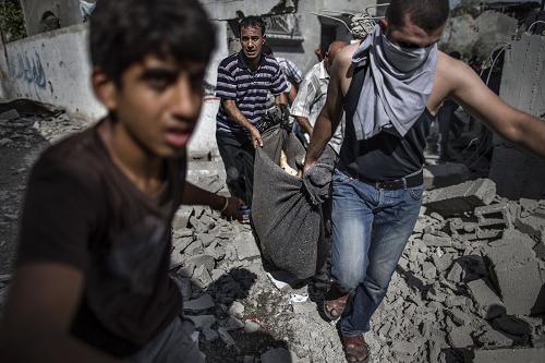 Palestinian recover the body of a man killed when his home was hit the previous night by Israeli fire in the northern district of Beit Hanun in the Gaza Strip during an humanitarian truce, on July 26, 2014. [Xinhua photo]