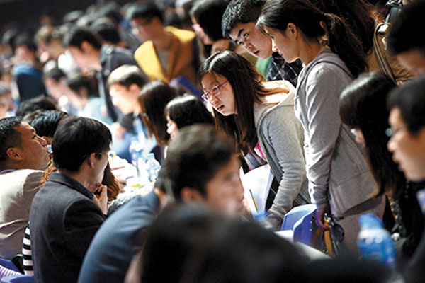 College students inquire about job opportunities during a job fair at Anhui university in Hefei, Anhui province, in April. The fair, for students who graduated in the spring, provided 5,000 positions. 