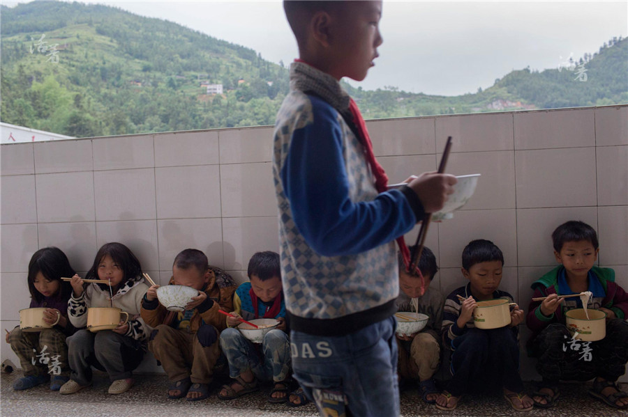 When the seats are all taken in the canteen, some students just squat themselves and eat rice noodles, which are a favorite of Yunna people. Since the construction of the building in 2007, compulsory education with free accommodation has been put into practice. In Xiong’s earlier teaching years, the school could not even afford a 10-yuan book. [Photo/qq.com]