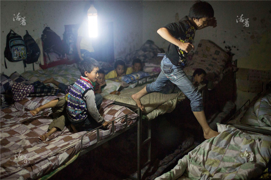 The originally brick-and-tile structured classrooms of 1997 are now the dormitory of boys with a small section for girls. At 10 in the evening after the lights have been turned off, some energetic boys are still jumping around. Although many facilities are still unavailable, the students at least have a warm bed. [Photo/qq.com]
