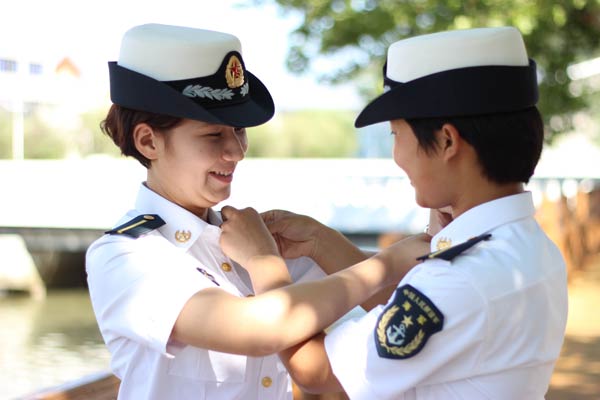 A Uygur student (left) checks a classmate's collar at Dalian Naval Academy in Liaoning province this summer. Zhou Hao / for China Daily
