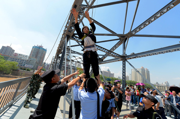 A 76-year-old man is rescued by police and firefighters after he attempted to commit suicide on a bridge across the Yellow River in Lanzhou, Gansu province, on July 3. [Photo/China Daily]