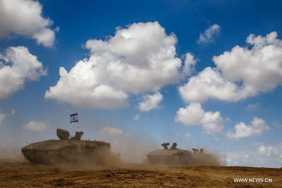 Israeli Armoured Personnel Carriers roll in southern Israel bordering the Gaza Strip as they return from Gaza, on Aug. 4, 2014. The Israeli military said Tuesday morning it has pulled back all of its ground forces from the Gaza Strip, as a three-day truce between Israel and Hamas went into effect. [Photo/Xinhua]