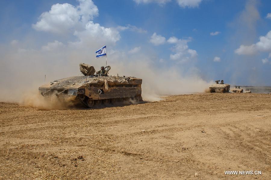 Israeli Armoured Personnel Carriers roll in southern Israel bordering the Gaza Strip as they return from Gaza, on Aug. 4, 2014. The Israeli military said Tuesday morning it has pulled back all of its ground forces from the Gaza Strip, as a three-day truce between Israel and Hamas went into effect. [Photo/Xinhua]