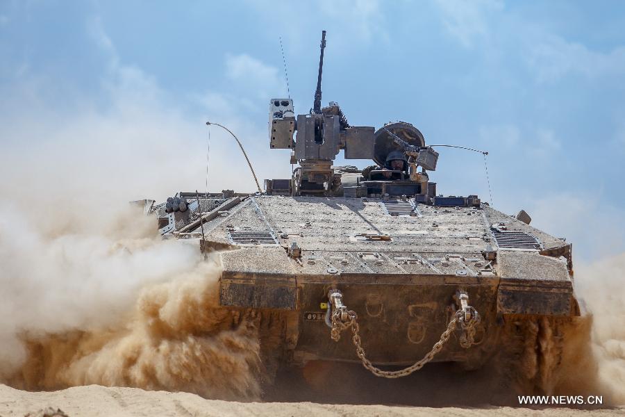 An Israeli Armoured Personnel Carrier rolls in southern Israel bordering the Gaza Strip as they return from Gaza, on Aug. 4, 2014. The Israeli military said Tuesday morning it has pulled back all of its ground forces from the Gaza Strip, as a three-day truce between Israel and Hamas went into effect. [Photo/Xinhua]