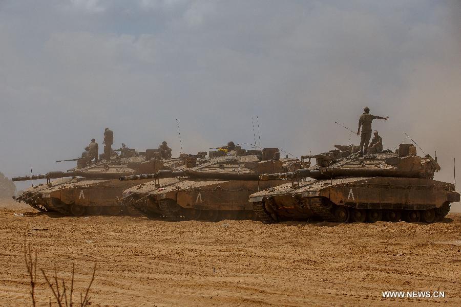 Israeli soldiers are seen atop of Merkava tanks at an army deployment area in southern Israel bordering the Gaza Strip, on Aug. 4, 2014. The Israeli military said Tuesday morning it has pulled back all of its ground forces from the Gaza Strip, as a three-day truce between Israel and Hamas went into effect.[Photo/Xinhua]