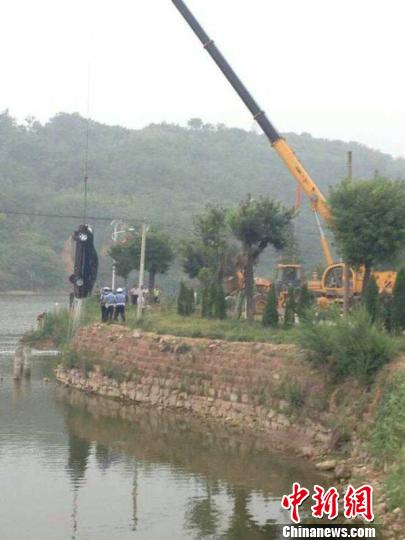 Local police retrieve a black car which ran into the reservoir at 3:45 p.m. on August 5, 2014. Yuan Zhigang, deputy head of the National People's Congress (NPC) of Xin'an County in central China's Henan province, was found in the car. He died at 58. Local authority says Yuan committed suicide and the investigation is still ongoing. [Photo / Chinanews.com] 