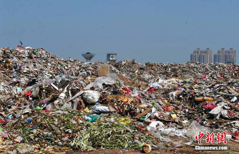 Photo taken on August 7, 2014 shows a 30 metres high garbage mountain at the crossroad of Huanghe avenue and Zhufeng street of Shijiazhuang, central China's Hebei province. The garbage mountain has been piled up as high as a 9-story Building in the last 30 years. The local village committee now is dealing with these wastes. [Photo: Chinanews.com]