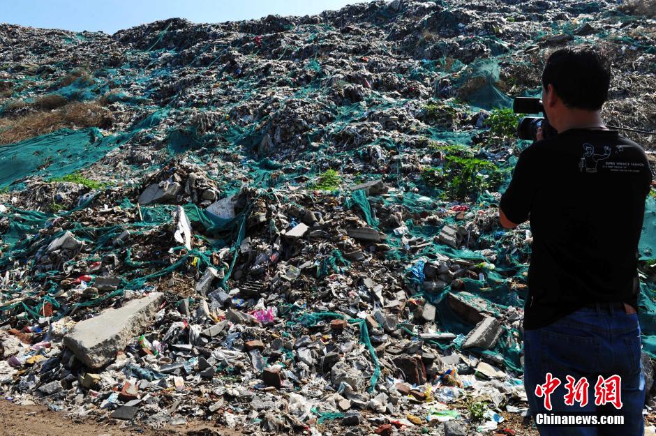 Photo taken on August 7, 2014 shows a 30 metres high garbage mountain at the crossroad of Huanghe avenue and Zhufeng street of Shijiazhuang, central China's Hebei province. The garbage mountain has been piled up as high as a 9-story Building in the last 30 years. The local village committee now is dealing with these wastes. [Photo: Chinanews.com] 