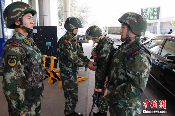 Beijing police authorities perform security checks on various vehicles entering the capital city on August 12, 2014. 