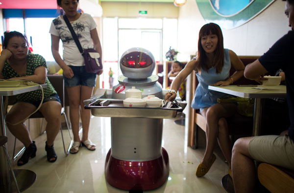 A robot carrying food to customers in a restaurant in Kunshan, Jiangsu province, on Wednesday. Johannes Eisele / Agence France Presse 