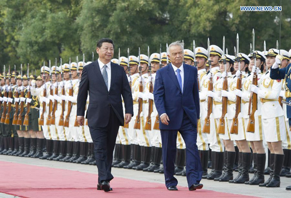 Chinese President Xi Jinping (L) and Uzbekistan's President Islam Karimov review the guard of honour during a welcoming ceremony prior to their talks in Beijing, capital of China, Aug. 19, 2014. [Photo/Xinhua]