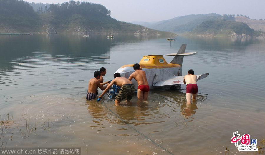 Villagers help Tan Yong to launch his homemade submarine for its maiden voyage in a river in Lijiashan village, Danjiangkou city, Central China's Hubei province, August 15, 2014.