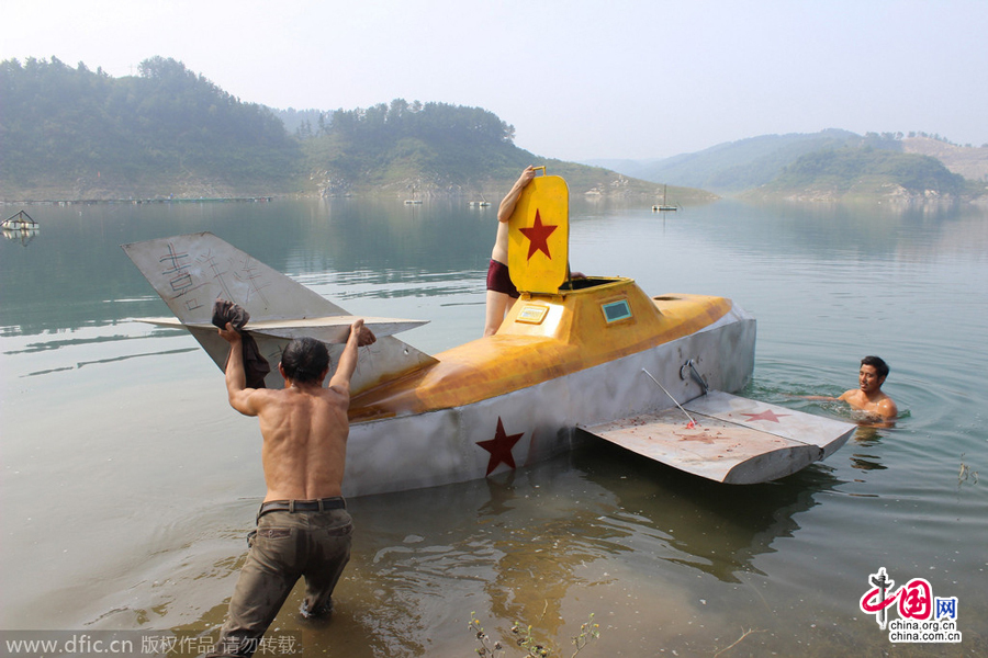 Villagers help Tan Yong to launch his homemade submarine for its maiden voyage in a river in Lijiashan village, Danjiangkou city, Central China's Hubei province, August 15, 2014. 