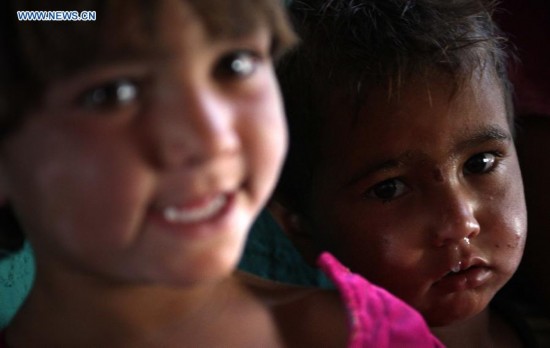 Afghan children are seen inside a tent at a displaced camp in Kabul, Afghanistan on Aug. 21, 2014. [Photo/Xinhua]