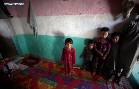 Afghan children stand inside a tent at a displaced camp in Kabul, Afghanistan on Aug. 21, 2014. [Photo/Xinhua]