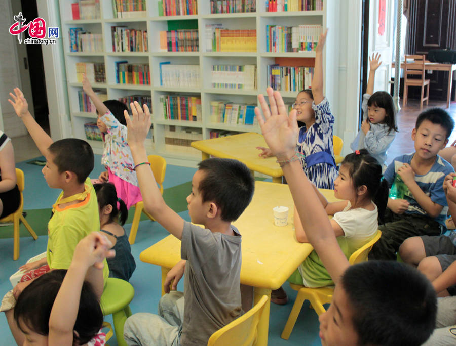 Children raise hands to ask questions to the two creators. [Photo by Li Shen/China.org.cn] 