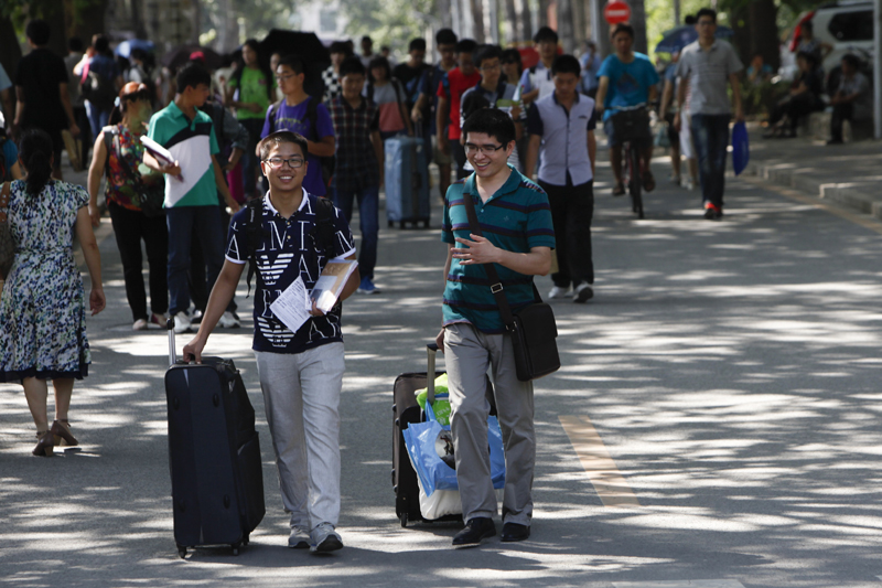 New students arrive on campus with their luggage. [Photo by Kuang Linhua/Asianewsphoto]