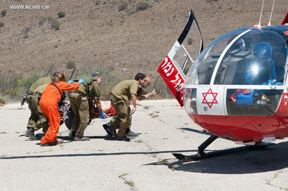 Israeli soldiers evacuate an wounded soldier on Golan Heights, on Aug. 27, 2014. [Photo/Xinhua]