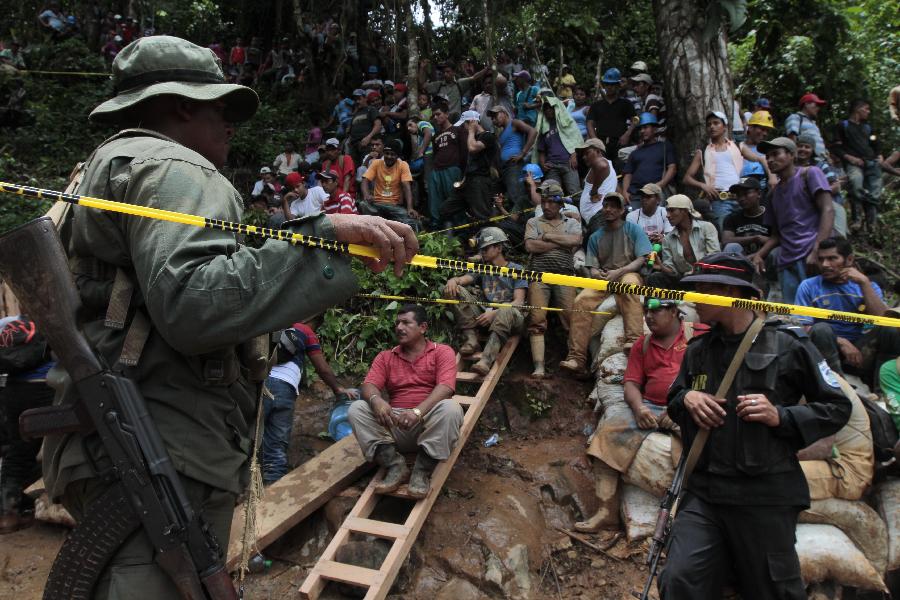 People gather in the area where a landslide took place at a mine in Bonanza Town, north Nicaragua, Aug. 29, 2014. At least 25 workers were trapped when a gold mine caved in on Thursday in Bonanza.