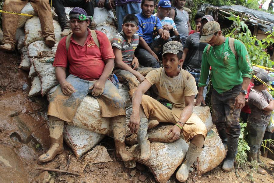 People gather in the area where a landslide took place at a mine in Bonanza Town, north Nicaragua, Aug. 29, 2014. At least 25 workers were trapped when a gold mine caved in on Thursday in Bonanza. 