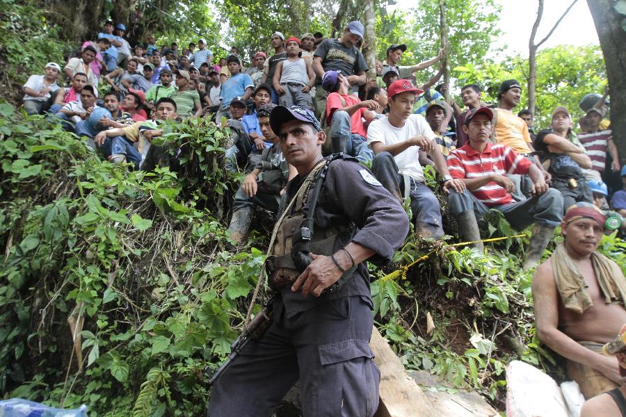 People gather in the area where a landslide took place at a mine in Bonanza Town, north Nicaragua, Aug. 29, 2014. At least 25 workers were trapped when a gold mine caved in on Thursday in Bonanza.