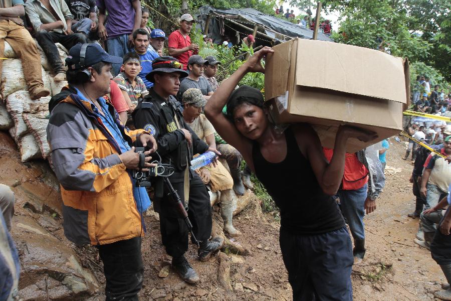 People gather in the area where a landslide took place at a mine in Bonanza Town, north Nicaragua, Aug. 29, 2014. At least 25 workers were trapped when a gold mine caved in on Thursday in Bonanza.