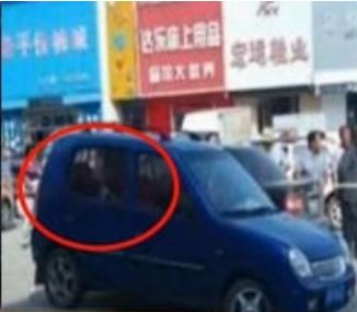 The window of a blue car gets shot in the downtown area of Kedong County, Qiqihar City, in northeast China's Heilongjiang Province on September 1, 2014. [Photo: hlj.people.cn]