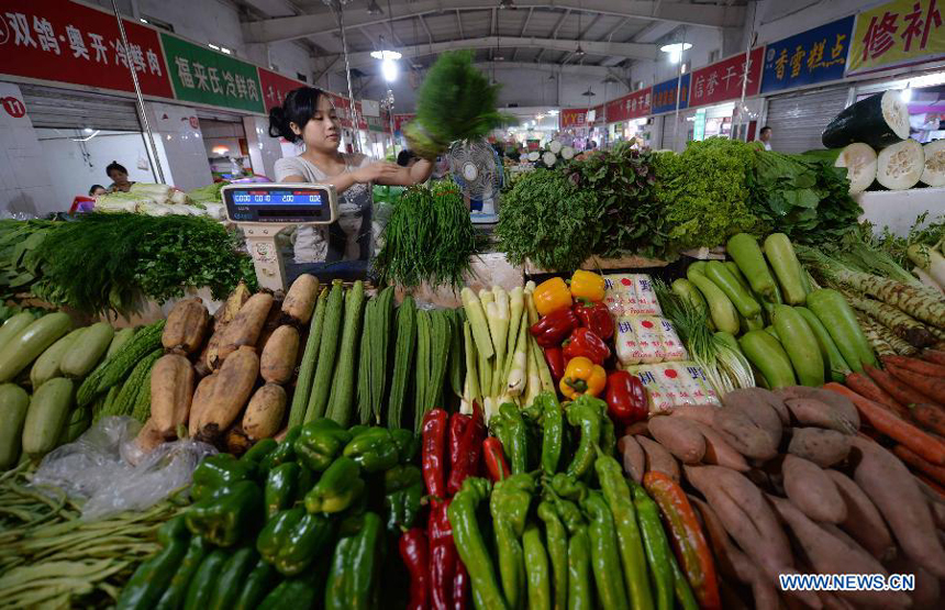 A vegetable dealer places vegetables in a market in Shijiazhuang, capital of north China&apos;s Hebei Province, Sept. 11, 2014. China&apos;s consumer price index, a main gauge of inflation, grew 2 percent year on year in August, the National Bureau of Statistics said Thursday. The August CPI growth rate was lower than the 2.3 percent seen in July.