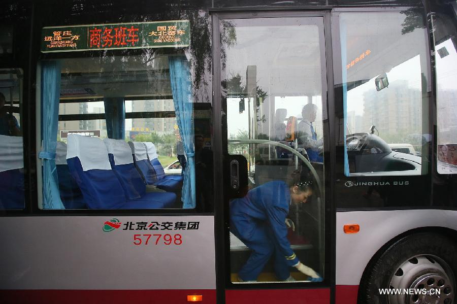 A crew member cleans a shuttle bus before departure near a residential community in Beijing, China, Sept. 9, 2013. [Photo: xinhua]