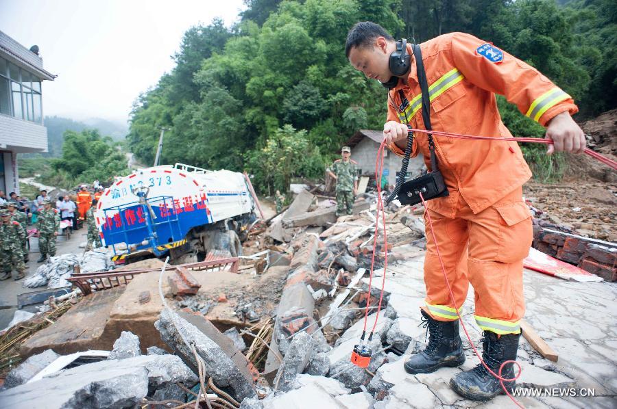 A rescuer uses a life detector to search for survivers at a landslide site in Changsheng Village of Changshou District in southwest China's Chongqing, Sept. 14, 2014. Downpours are wreaking havoc in southwest China Saturday. Landslides triggered by continuous rainfalls have killed at least three people here and more buried are yet to be found. (Xinhua/Liu Chan)