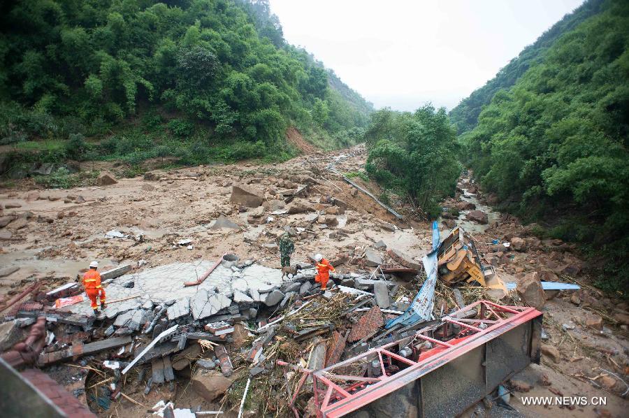 Rescuers work at a landslide site in Changsheng Village of Changshou District in southwest China's Chongqing, Sept. 14, 2014. Downpours are wreaking havoc in southwest China Saturday. Landslides triggered by continuous rainfalls have killed at least three people here and more buried are yet to be found. (Xinhua/Liu Chan)