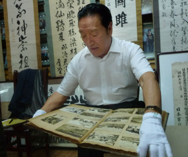 Song Jinhe, a 67-year-old retired cadre in Heilongjiang province, shows documents and photographs he has collected that feature Japan's historical aggression against China. Zhou Huiying / China Daily 